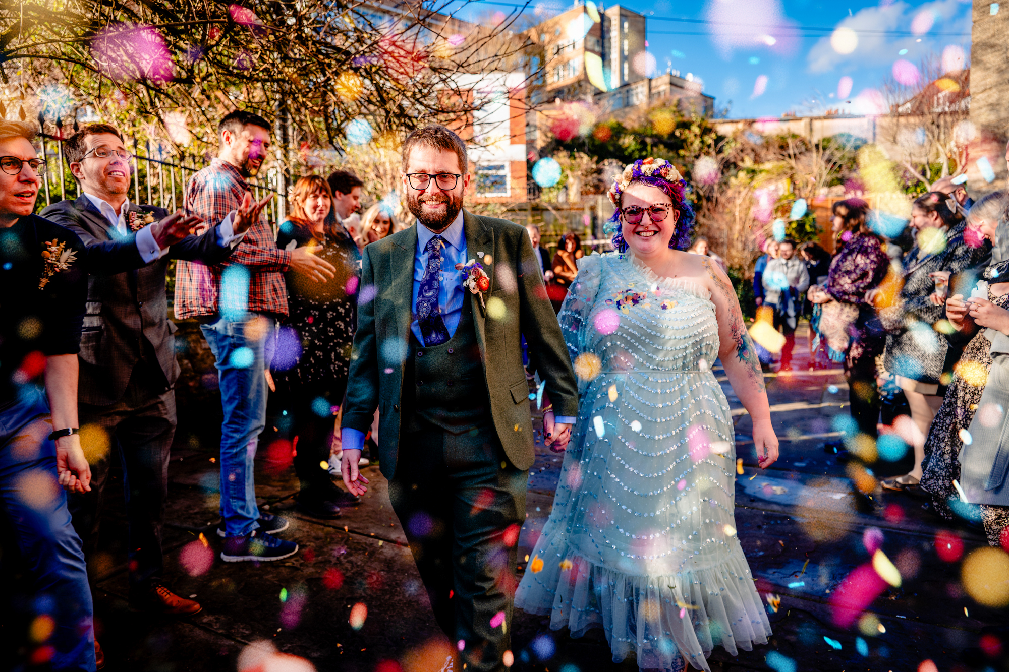 Colourful confetti moment with couple walking through guests after Bristol ceremony.