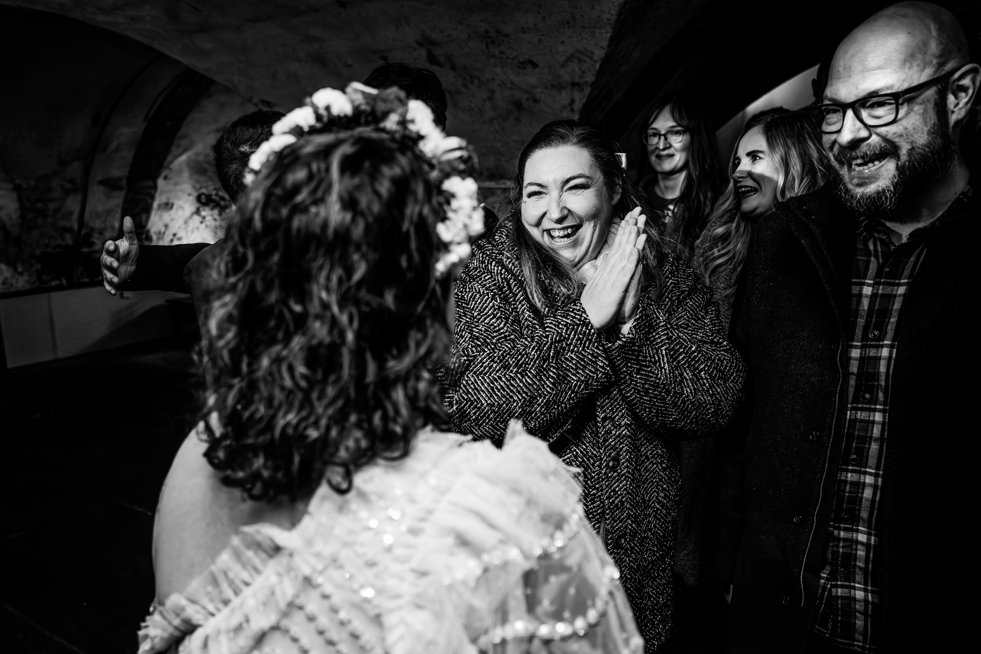 Guests laughing and clapping during candid wedding moment inside The Mount Without in Bristol.