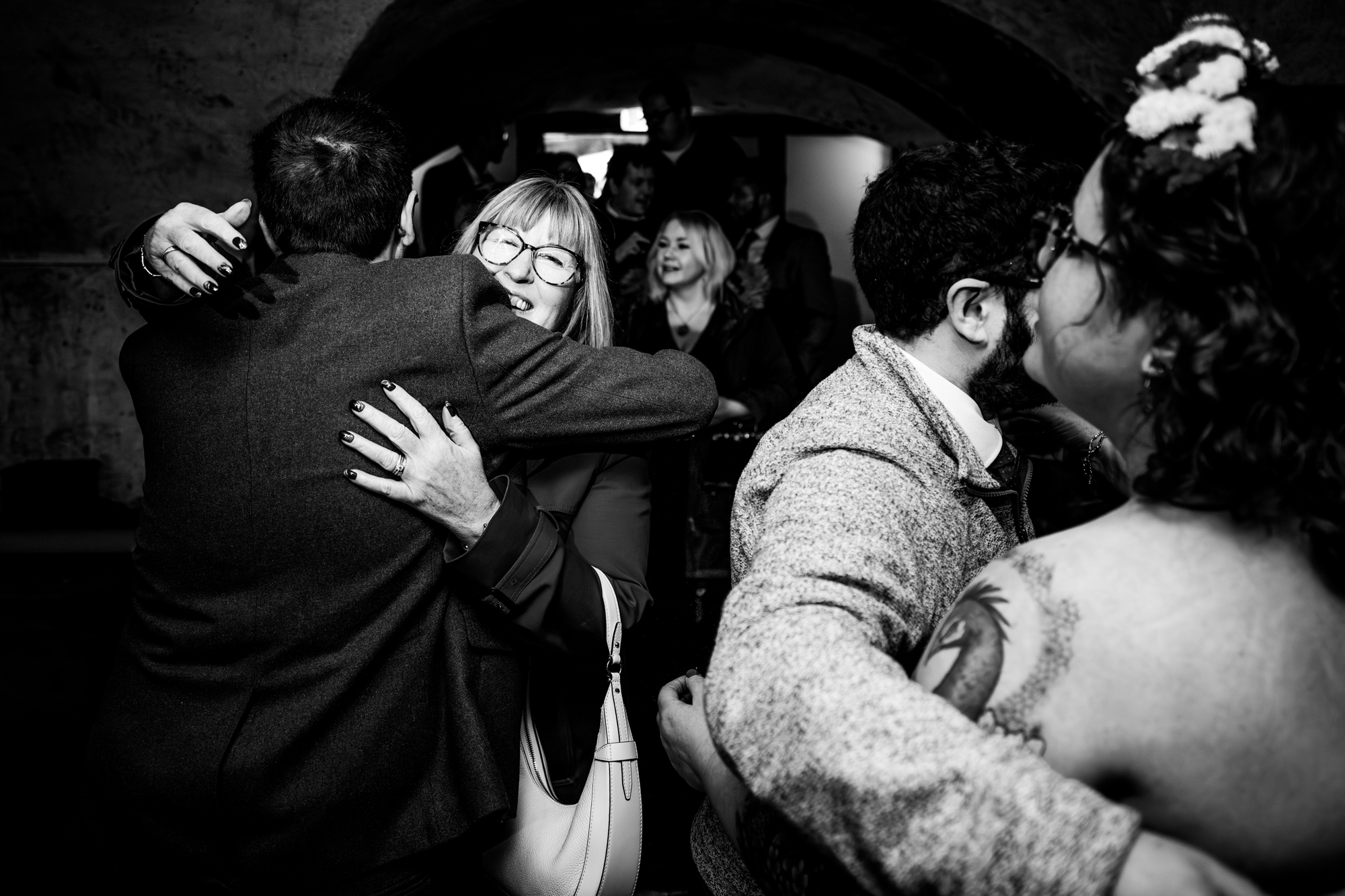 Guests embracing and greeting each other in candlelit space at The Mount Without wedding in Bristol.