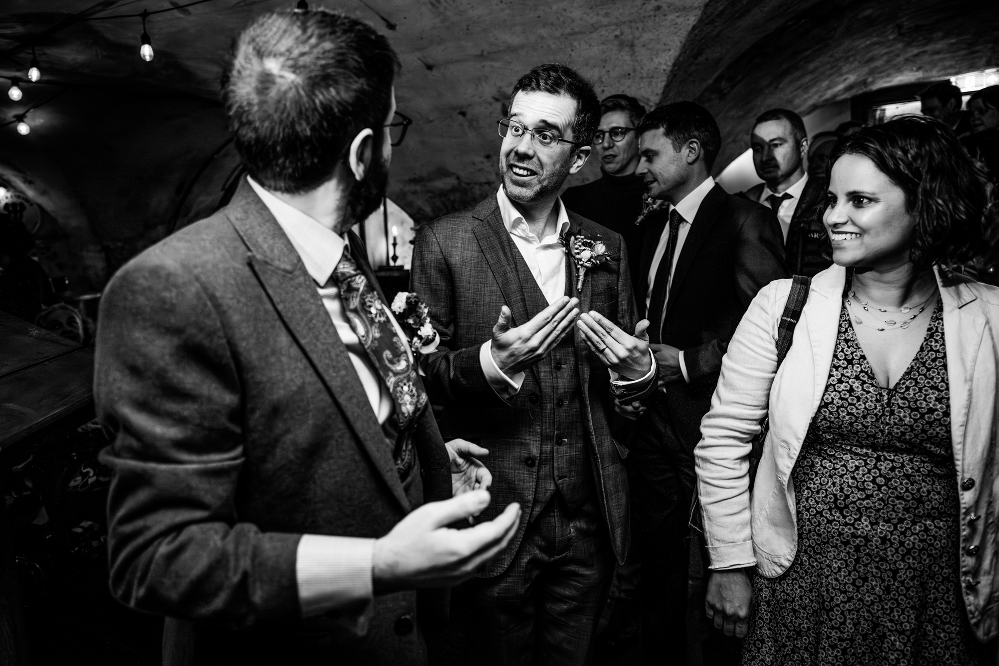 Group of wedding guests chatting and reacting during lively reception