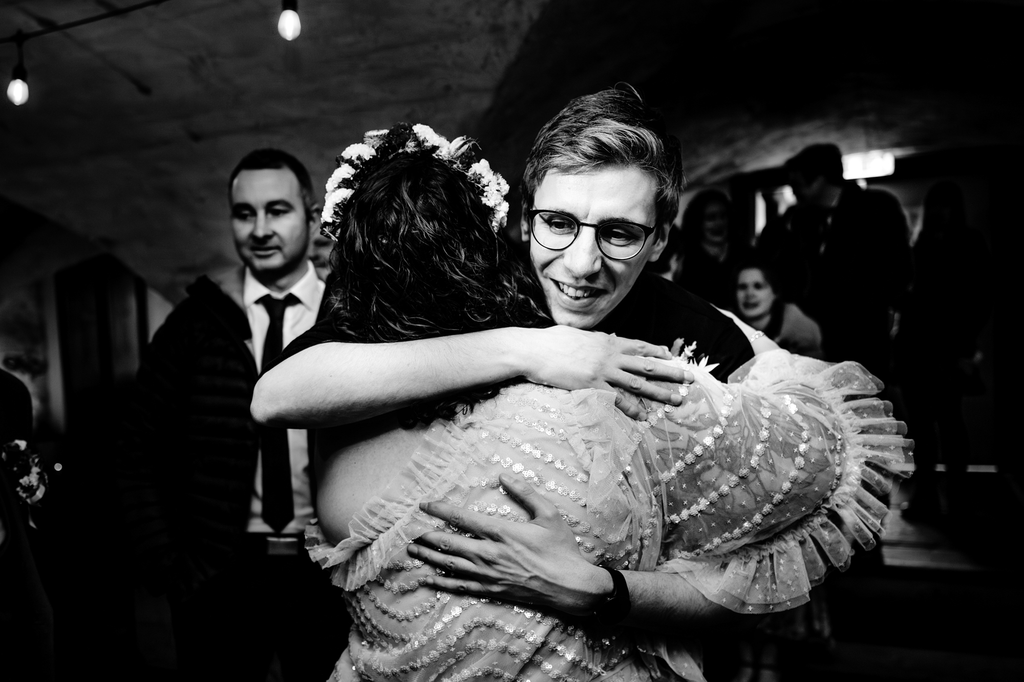 Guest hugging the couple with emotion during wedding celebration