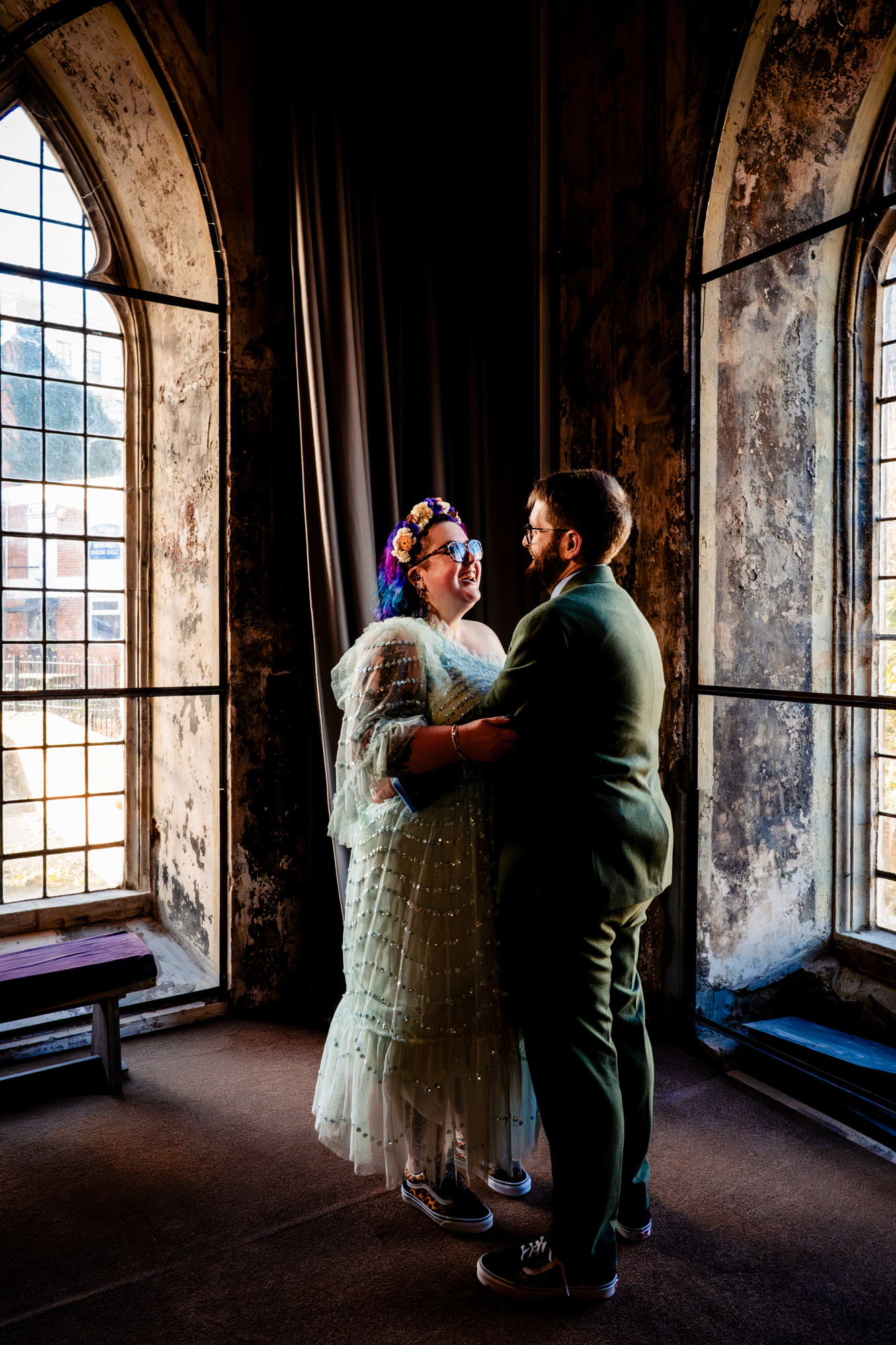 Couple sharing quiet moment by large arched windows inside The Mount Without Bristol.