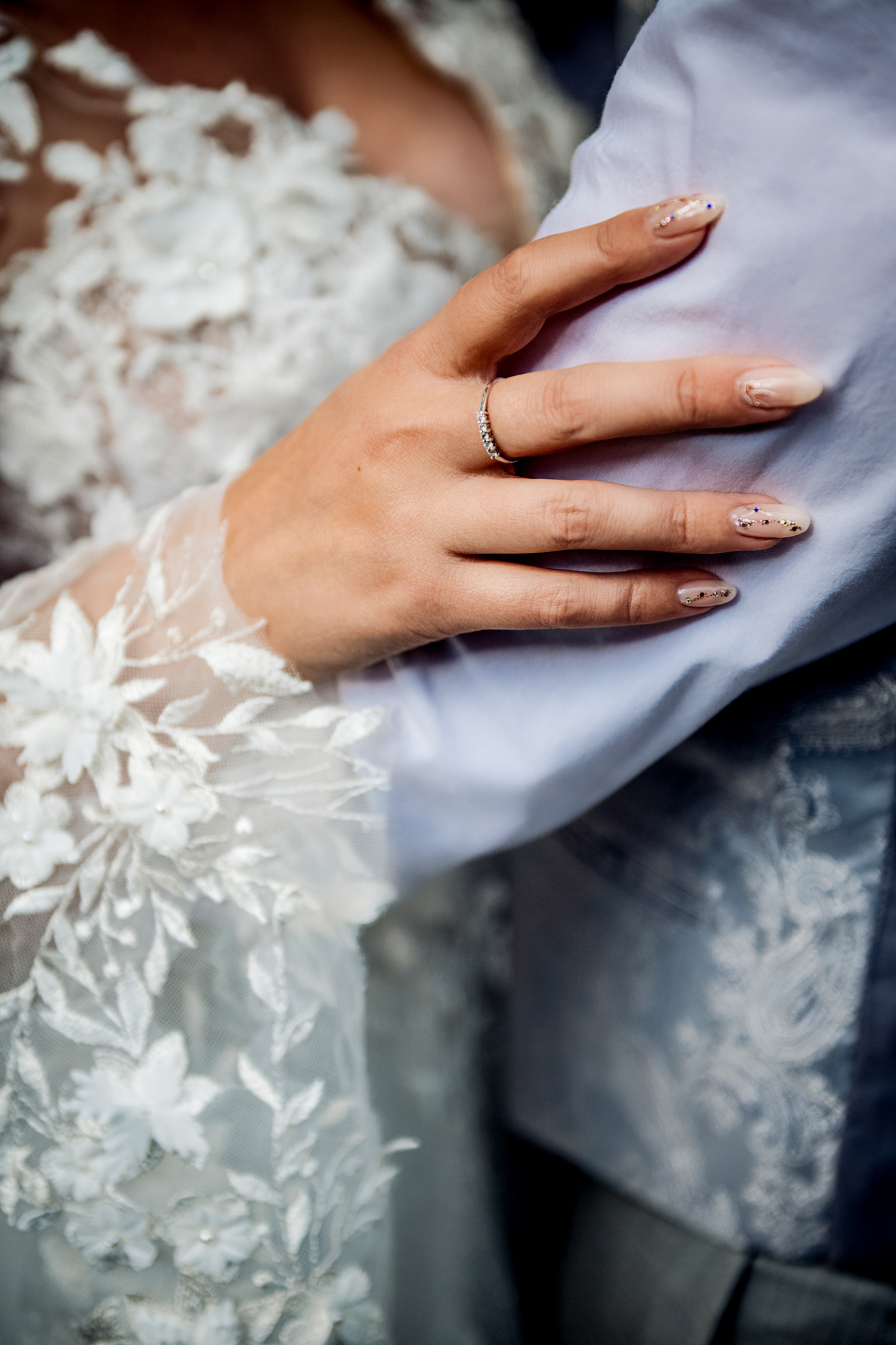 Emma’s hand resting gently on Steve’s arm, showing lace sleeve and soft detail.