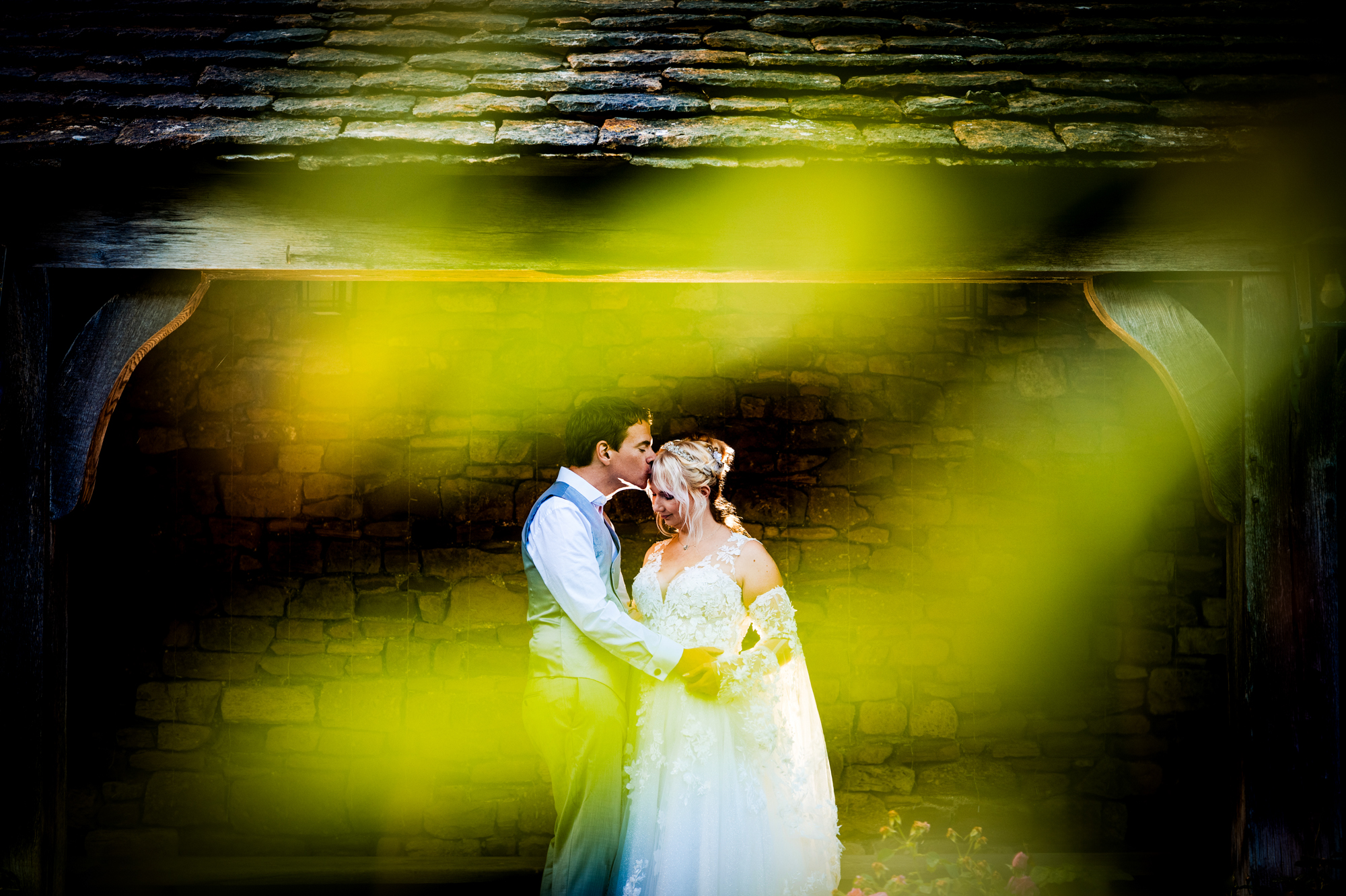 Emma and Steve are standing close together, framed by greenery in a quiet moment.