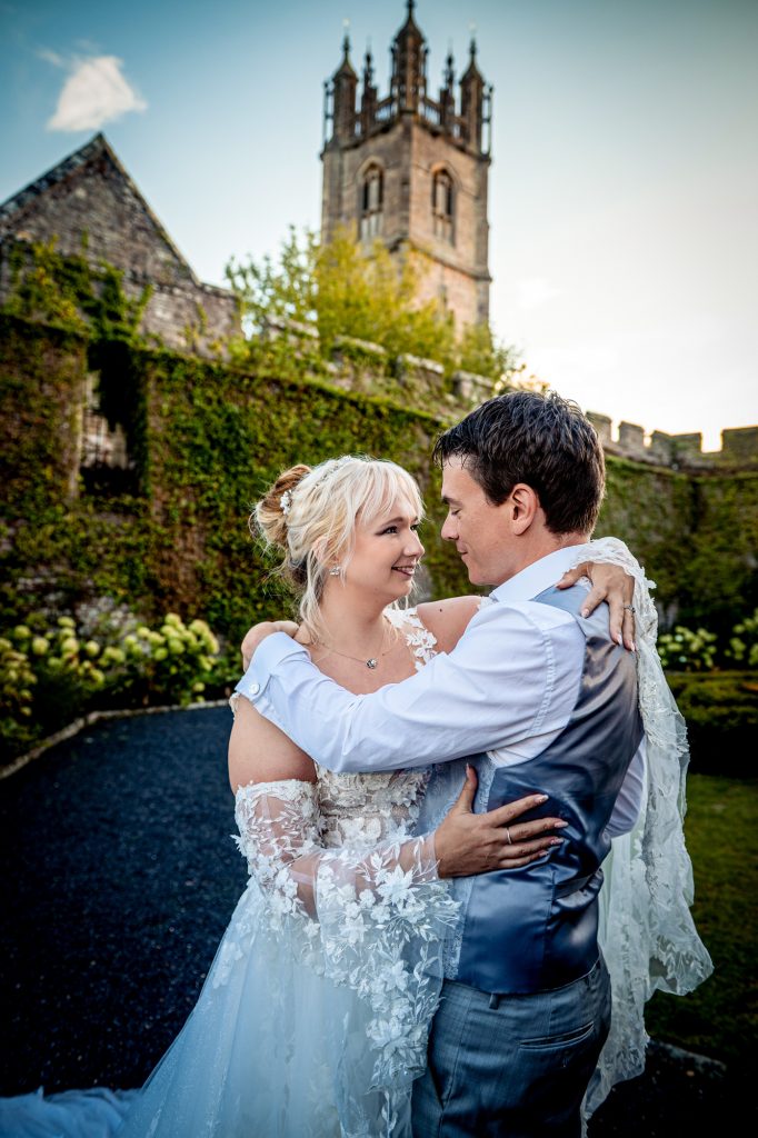 A couple holding each other closely in a quiet garden setting during their anniversary session.