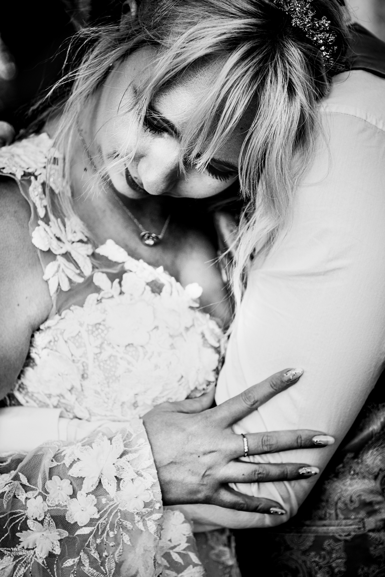 Intimate close-up of the bride resting against the groom, a soft, emotional moment.
