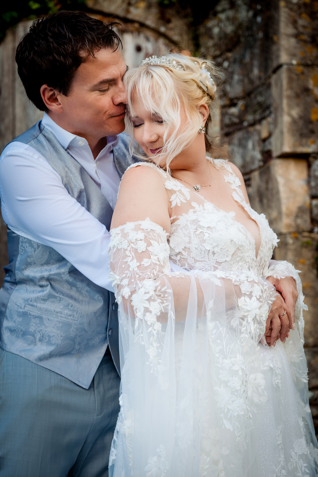 Emma and Steve embracing during their anniversary session at Thornbury Castle in soft natural light.