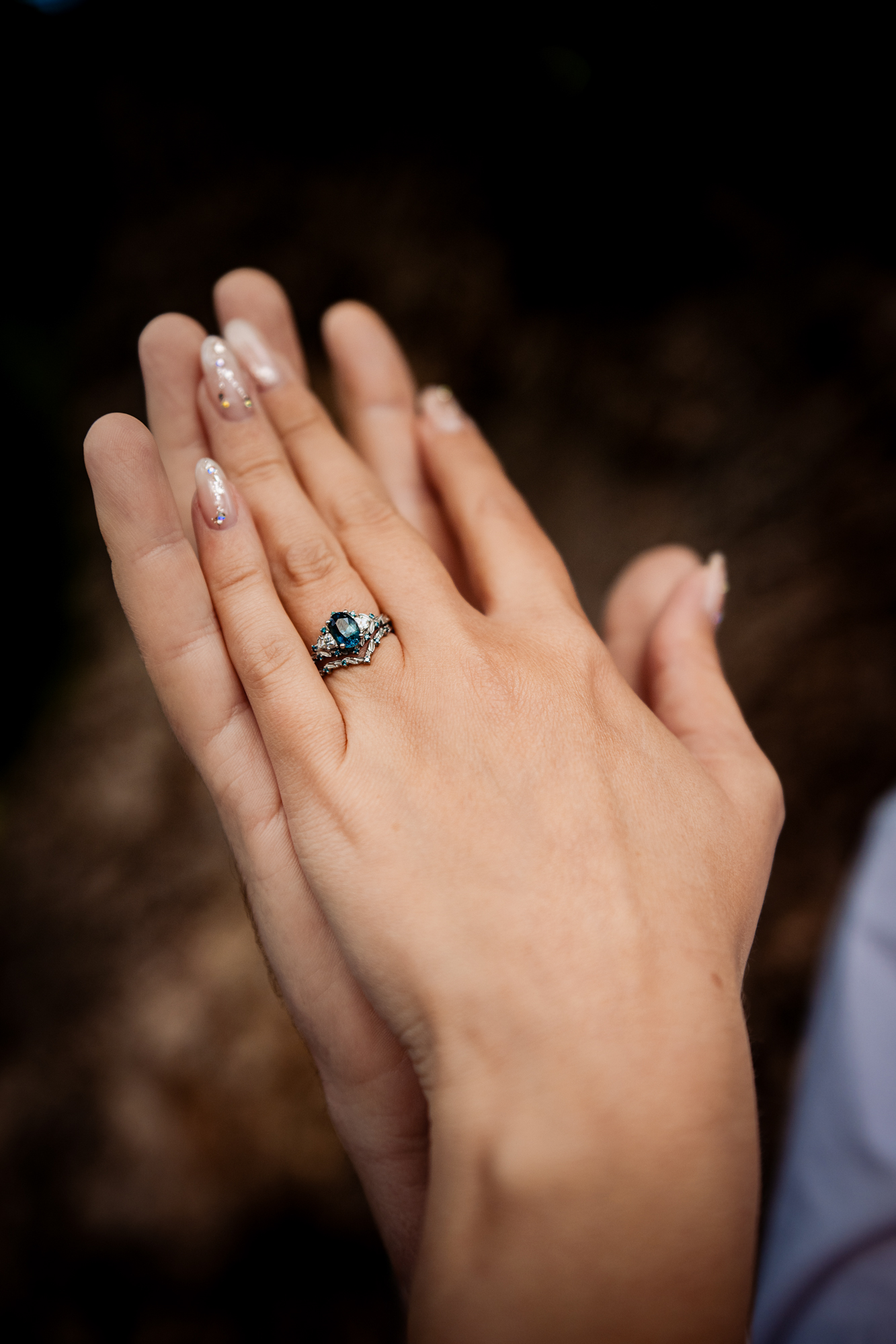 Detailed view of Emma’s engagement ring with soft background during their anniversary session.