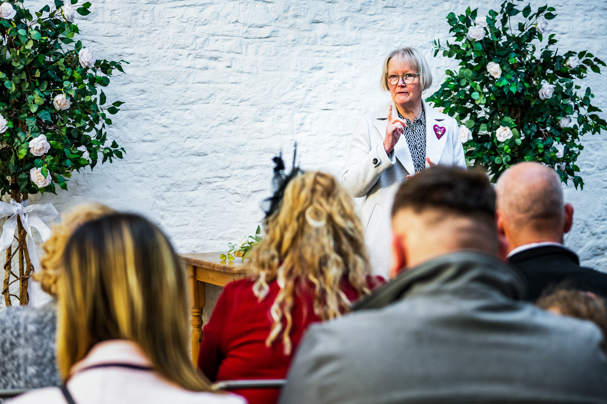 A celebrant speaks during the ceremony as guests watch from their seats.