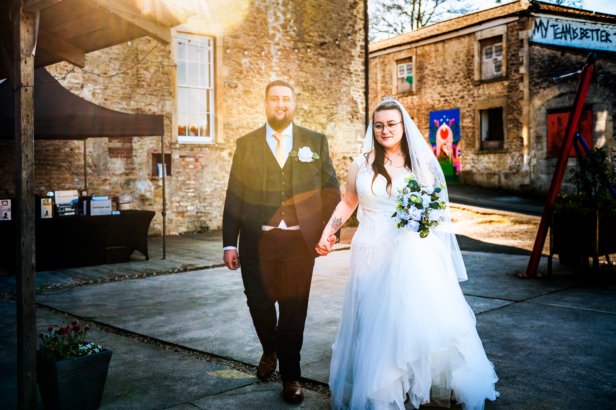 Nat and Jon walk hand in hand through the courtyard before their Silk Mill Studios wedding ceremony.