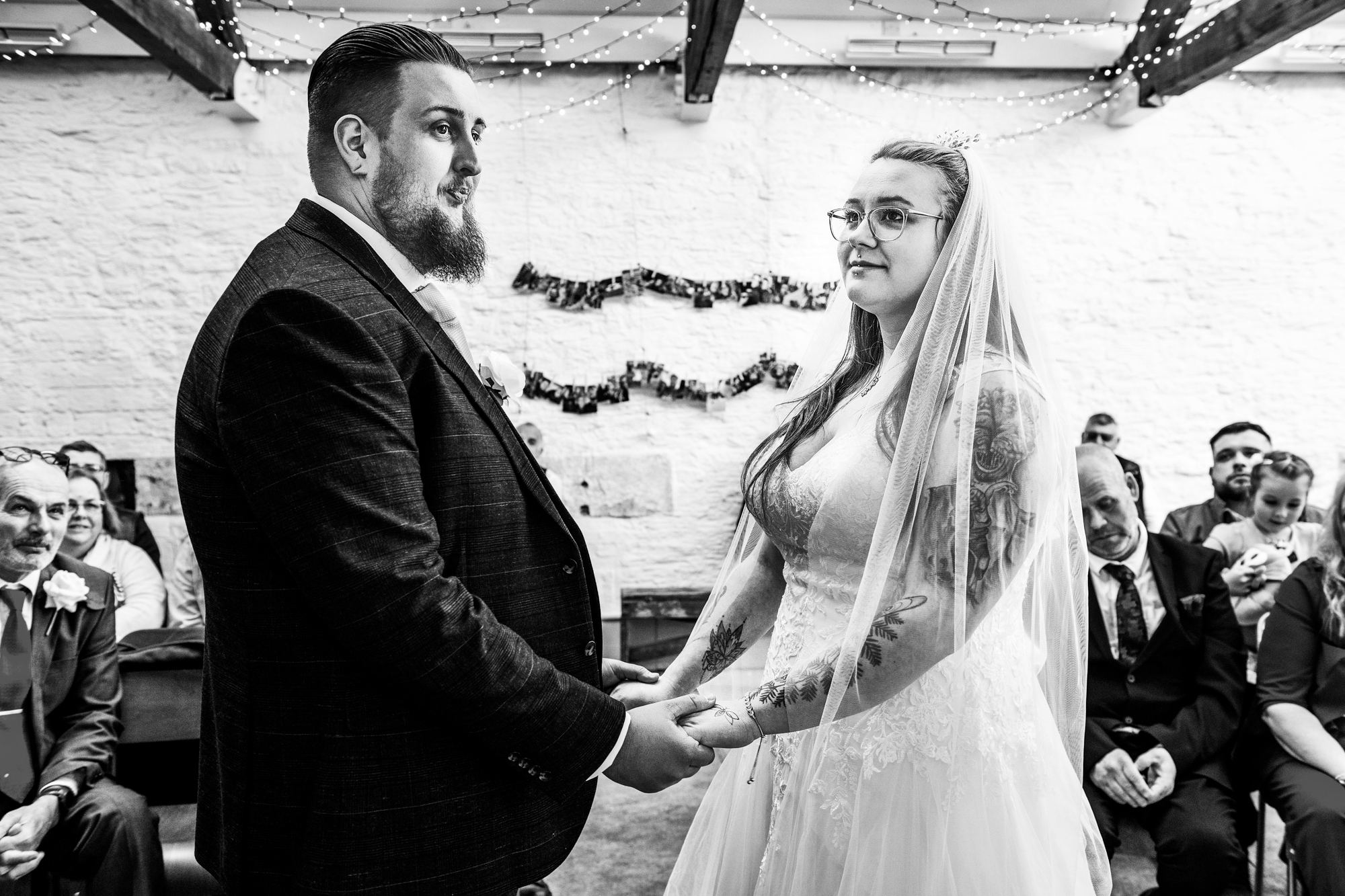 The bride and groom are holding each other's hand during their wedding ceremony at Silk Mill Studios, Frome.