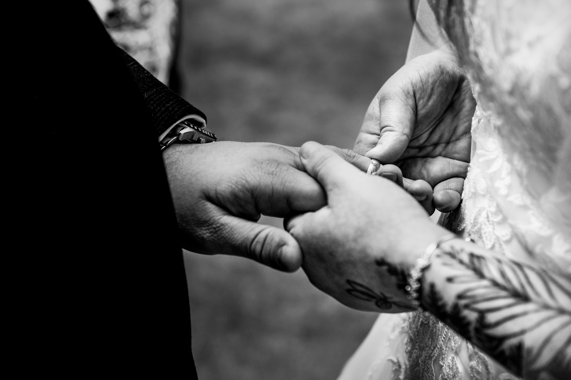 Close-up of Jon placing Nat’s wedding ring onto her hand during the ceremony.