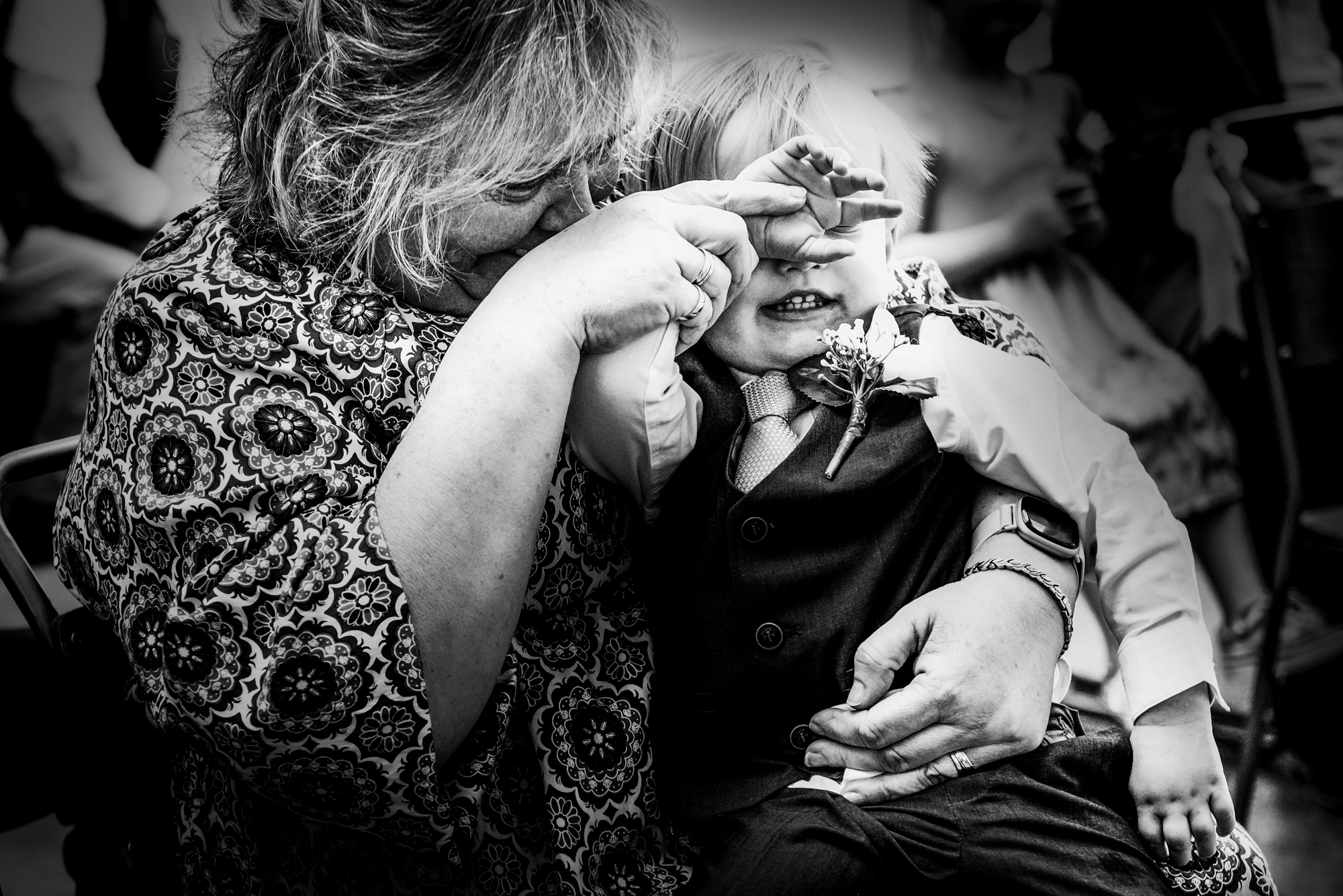 Little boy cuddles into a family member during the ceremony at Silk Mill Studios.