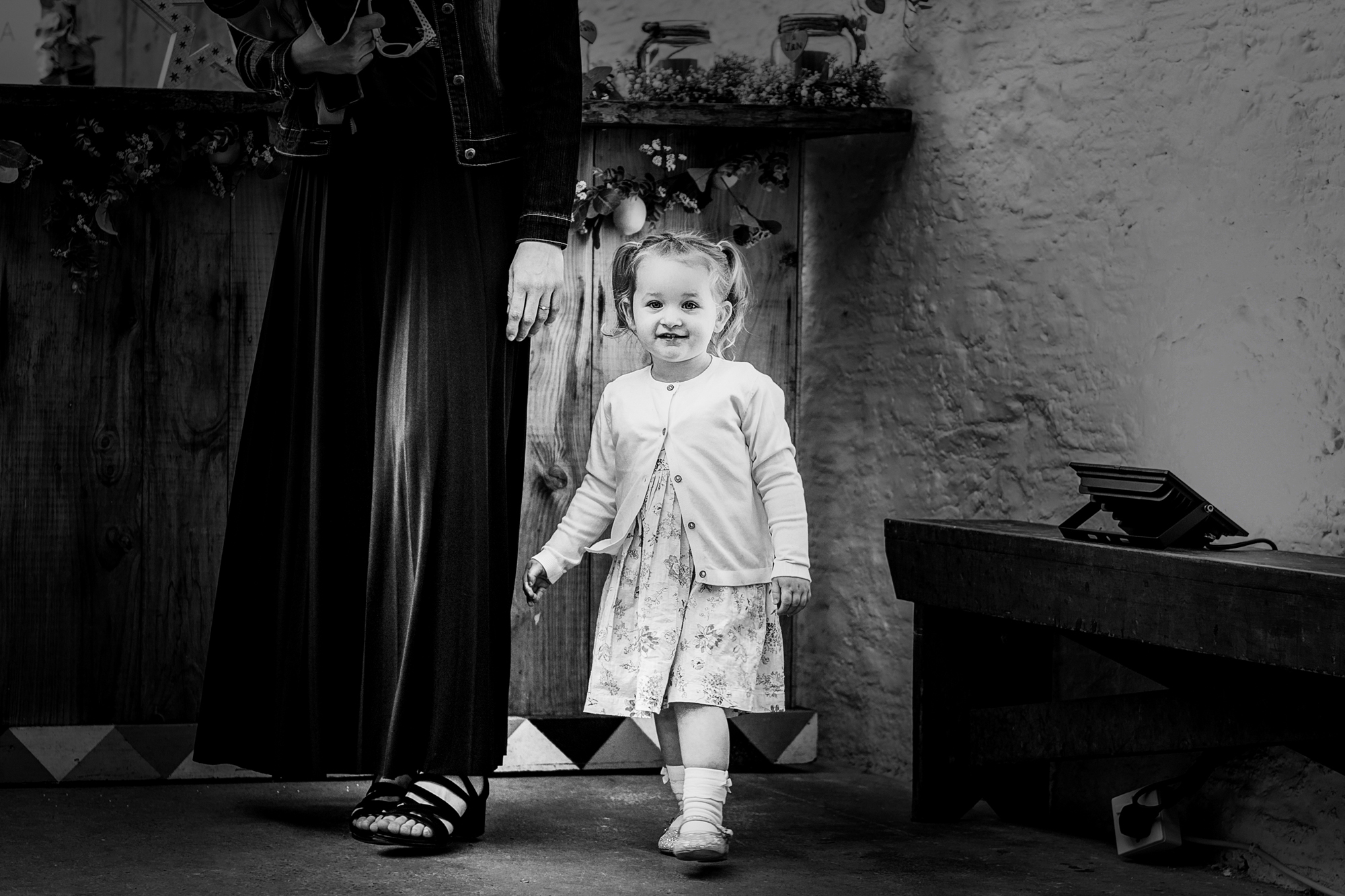 A little girl stands beside an adult during the wedding at Silk Mill Studios in Frome.