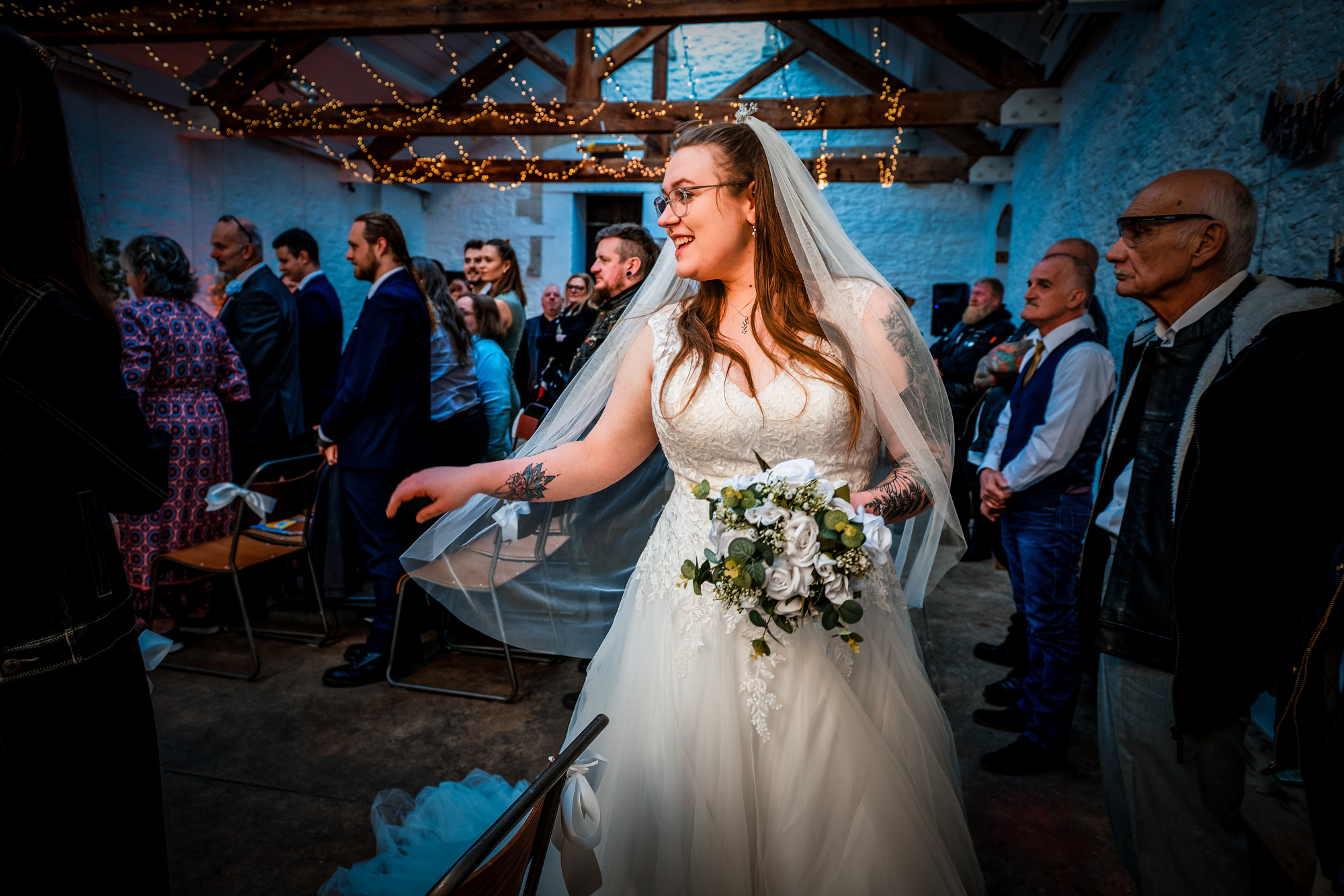 Nat reaches toward guests after the ceremony in the fairy-lit room at Silk Mill Studios.