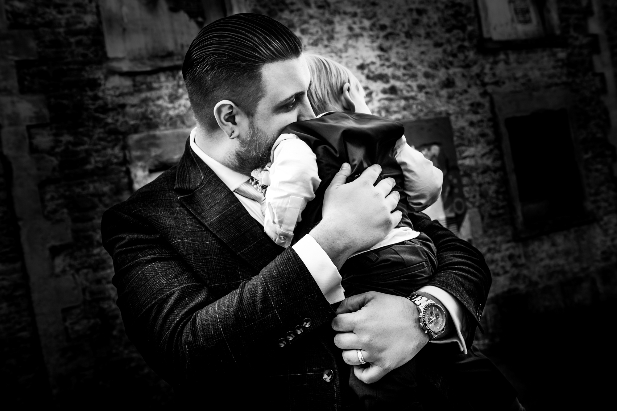 Jon hugs Theo close in a quiet black and white portrait outside the venue.