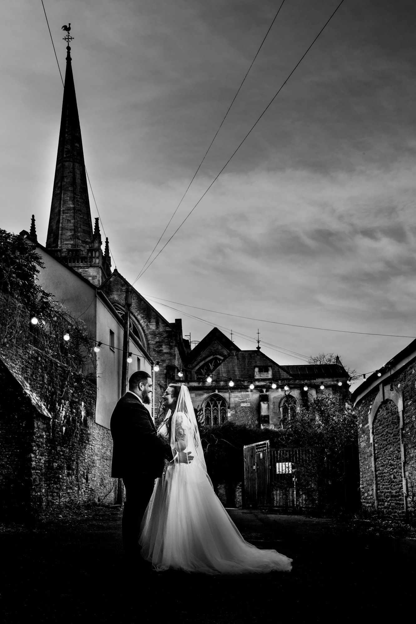 Nat and Jon stand together beneath the church spire near Silk Mill Studios in Frome.