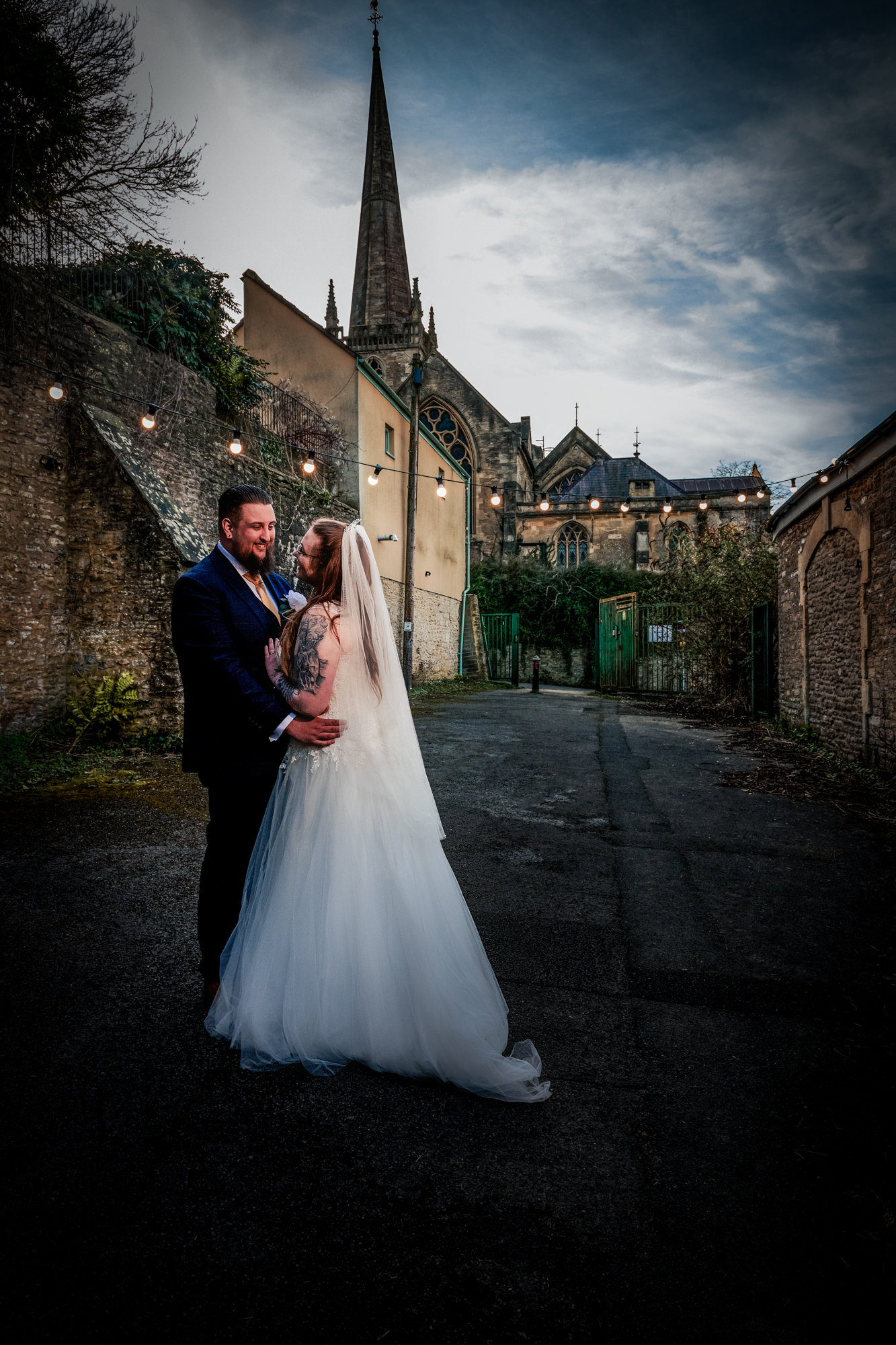 Nat and Jon stand together outside Silk Mill Studios with the church spire behind them.