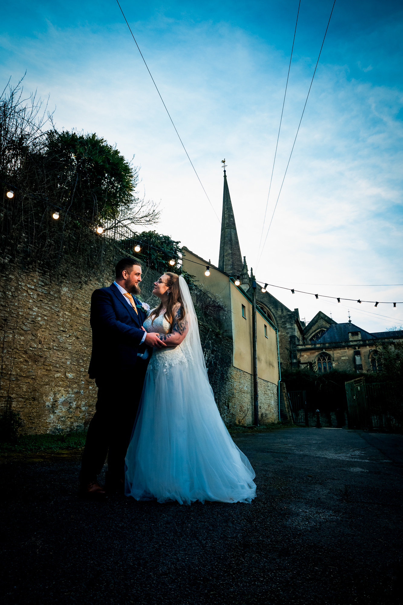 Nat and Jon stand together outside Silk Mill Studios with the church spire rising behind them.