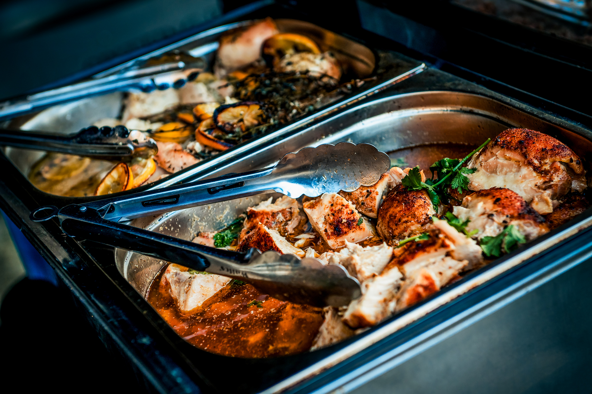 Close-up of roast chicken trays served as part of the wedding meal at Silk Mill Studios.