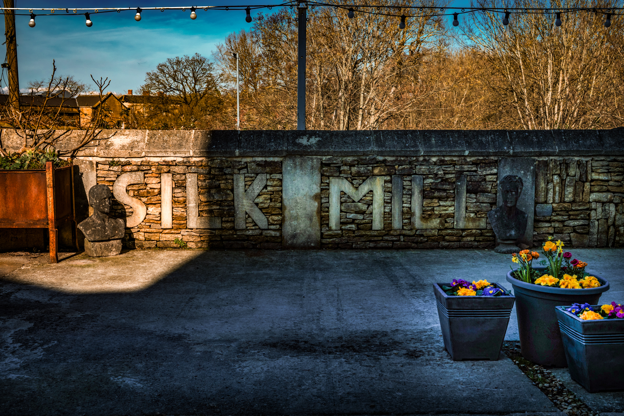 Silk Mill Studios sign set into a stone wall in the courtyard at the Frome wedding venue.
