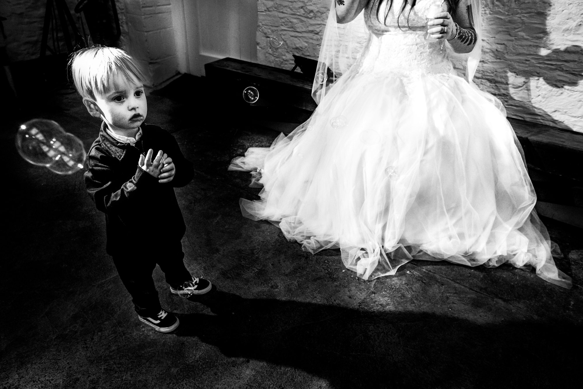 Little boy stands beside Nat’s dress while bubbles drift through the room.
