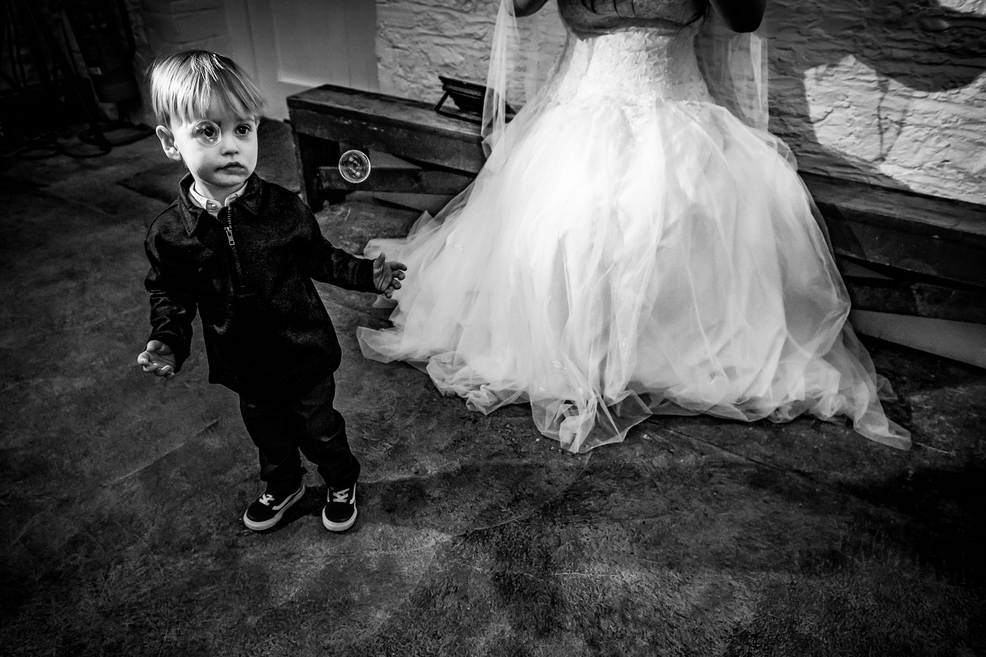 Little boy watches bubbles beside Nat’s wedding dress inside Silk Mill Studios.