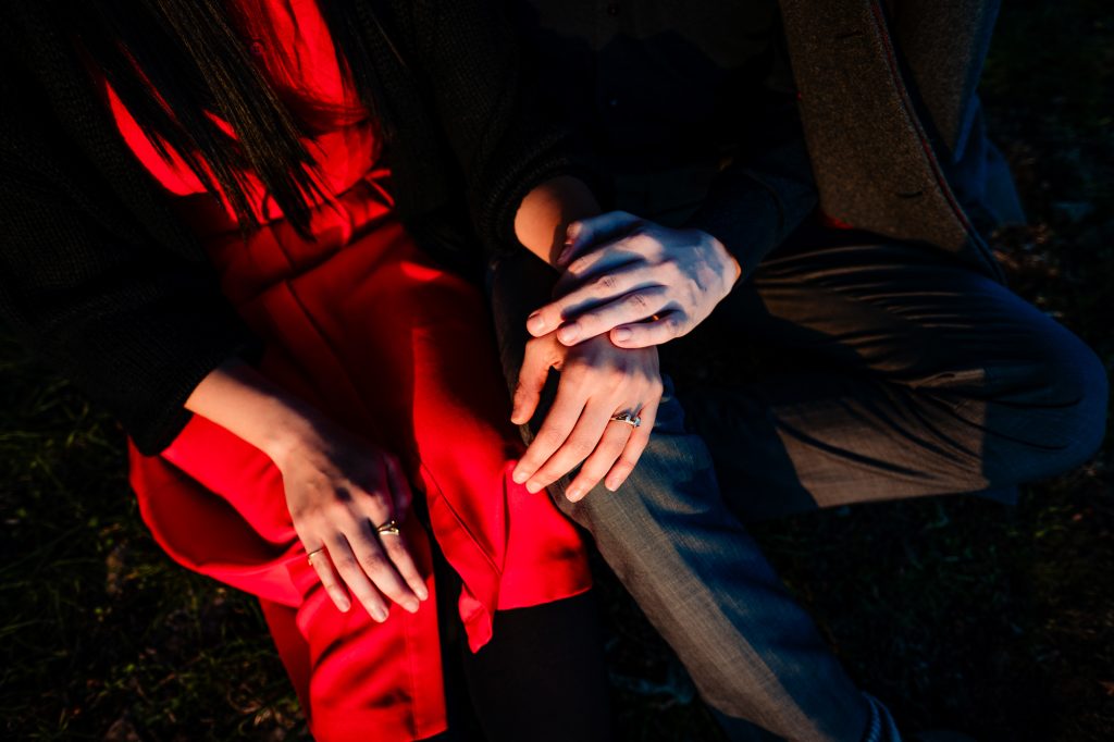 Close-up of clasped hands and engagement rings during Clifton evening couple session.