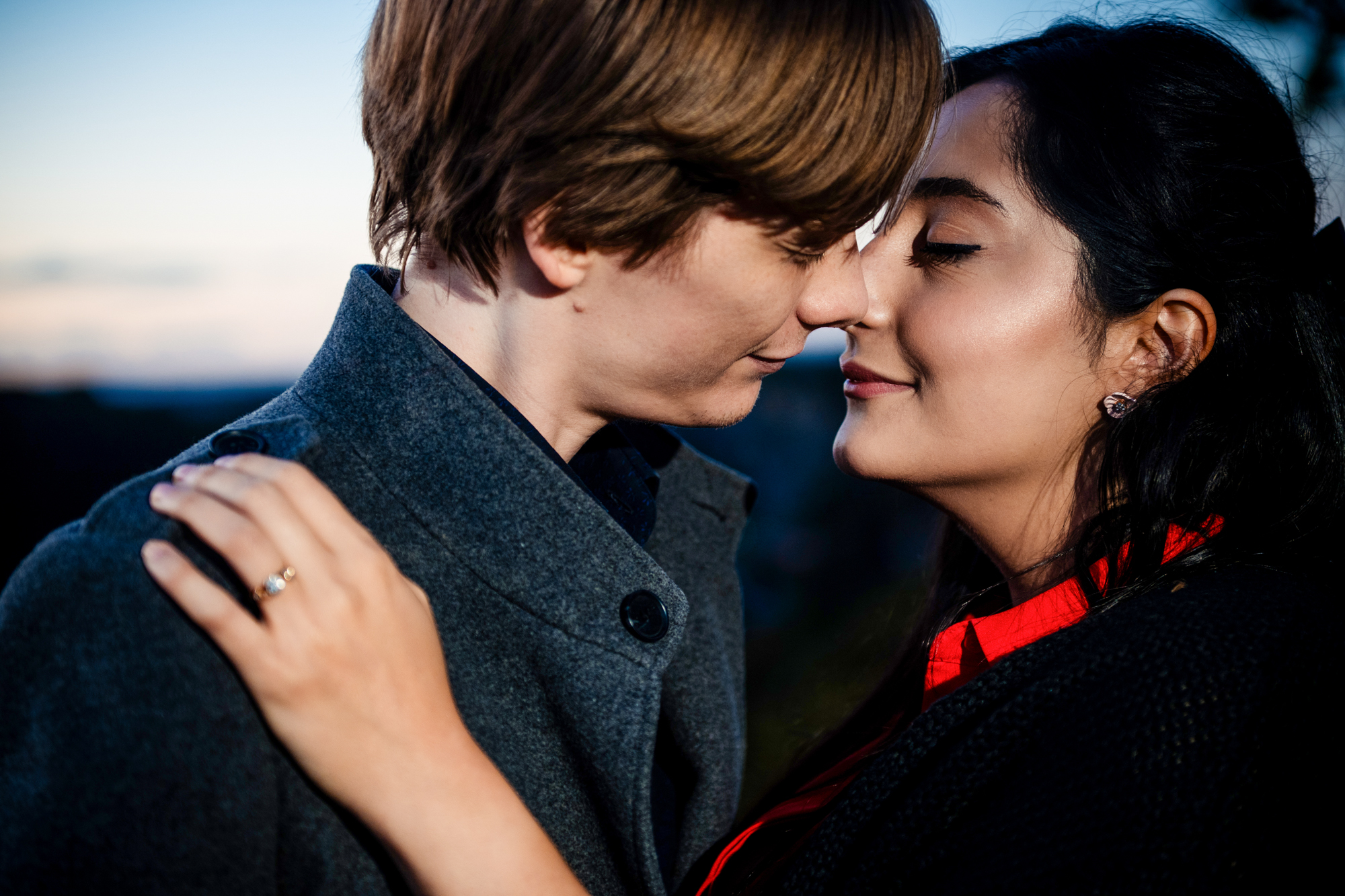Close-up portrait of engaged couple touching noses during blue-hour Clifton session.