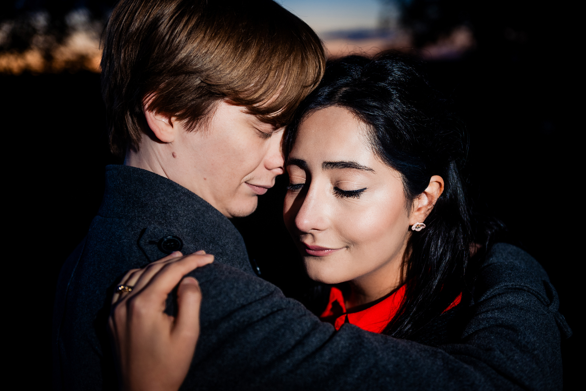 Close-up portrait of couple embracing softly during twilight engagement shoot in Clifton.