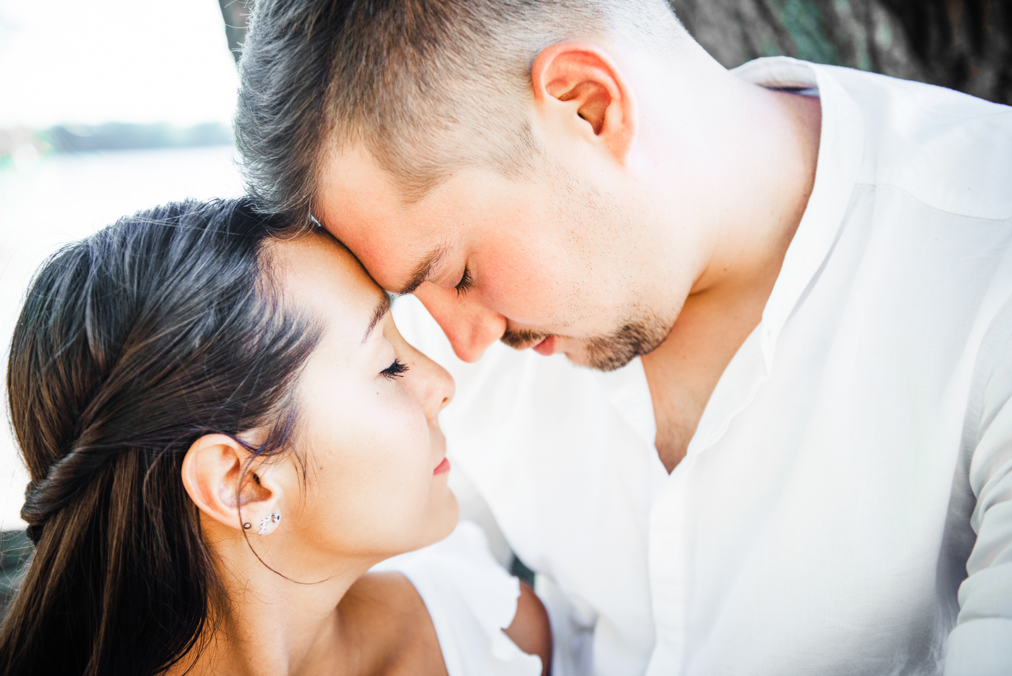Couple leaning into each other in soft golden light during relaxed engagement session by the Danube.