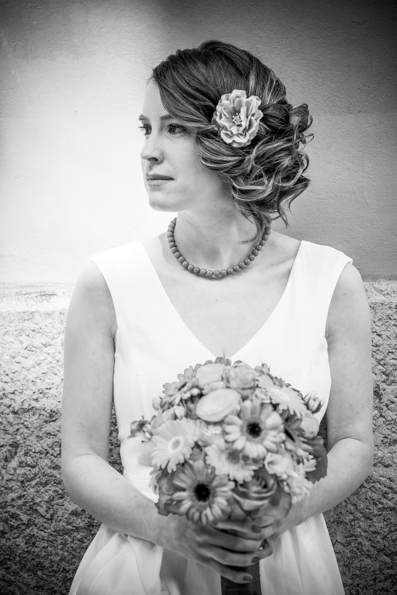 Bride holding bouquet looks away in soft black and white portrait during Rovinj engagement session.
