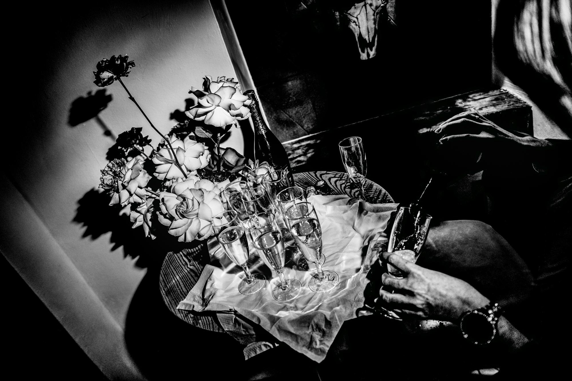 Champagne glasses and flowers arranged on a small table during the wedding party.