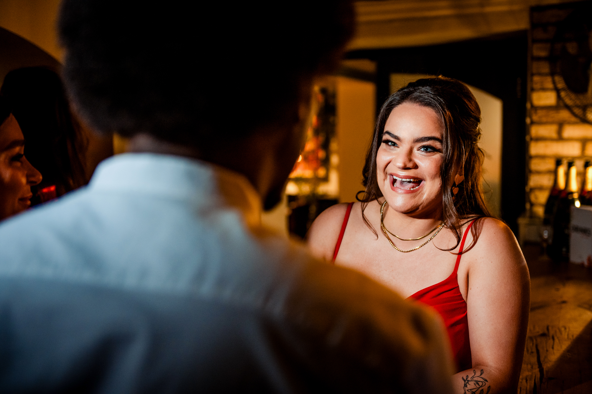Smiling wedding guest in a red dress chatting during the evening reception at Racks Bristol.