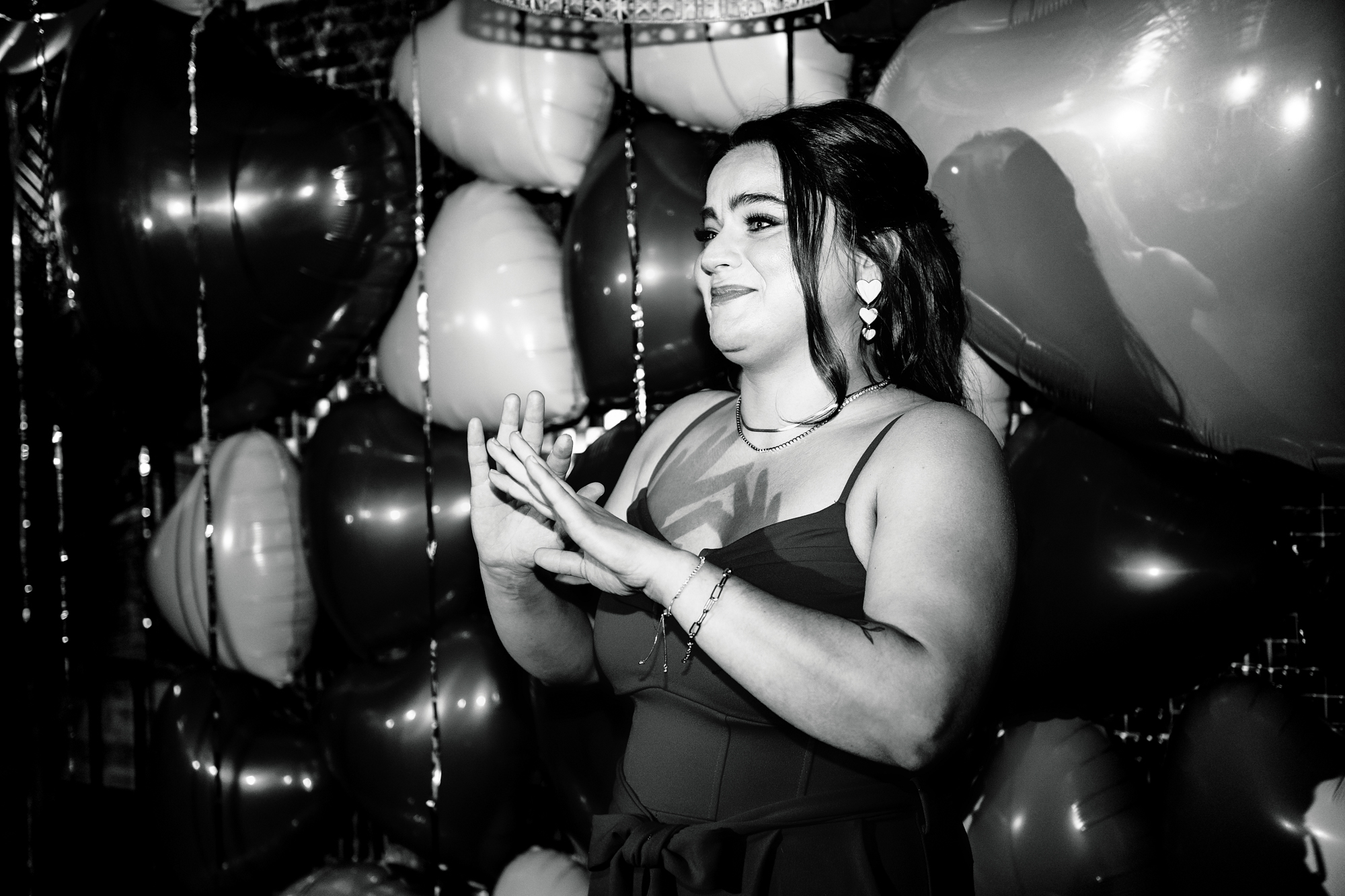 Smiling guest standing beside balloons during the evening celebration.