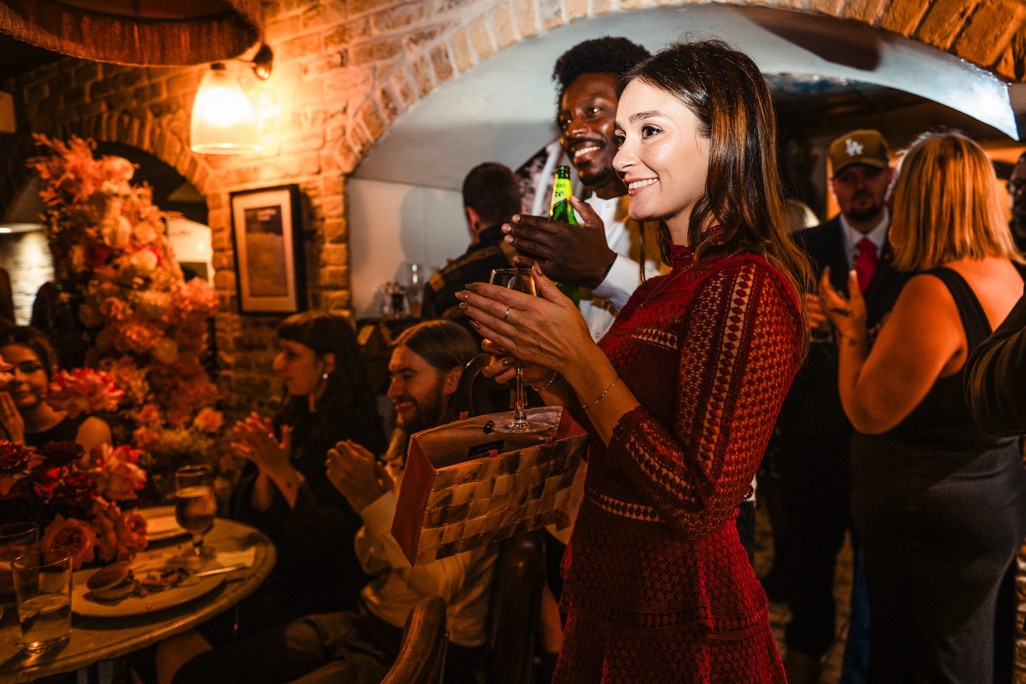Guests applaud and smile beneath brick arches during the wedding party at Racks Bristol.