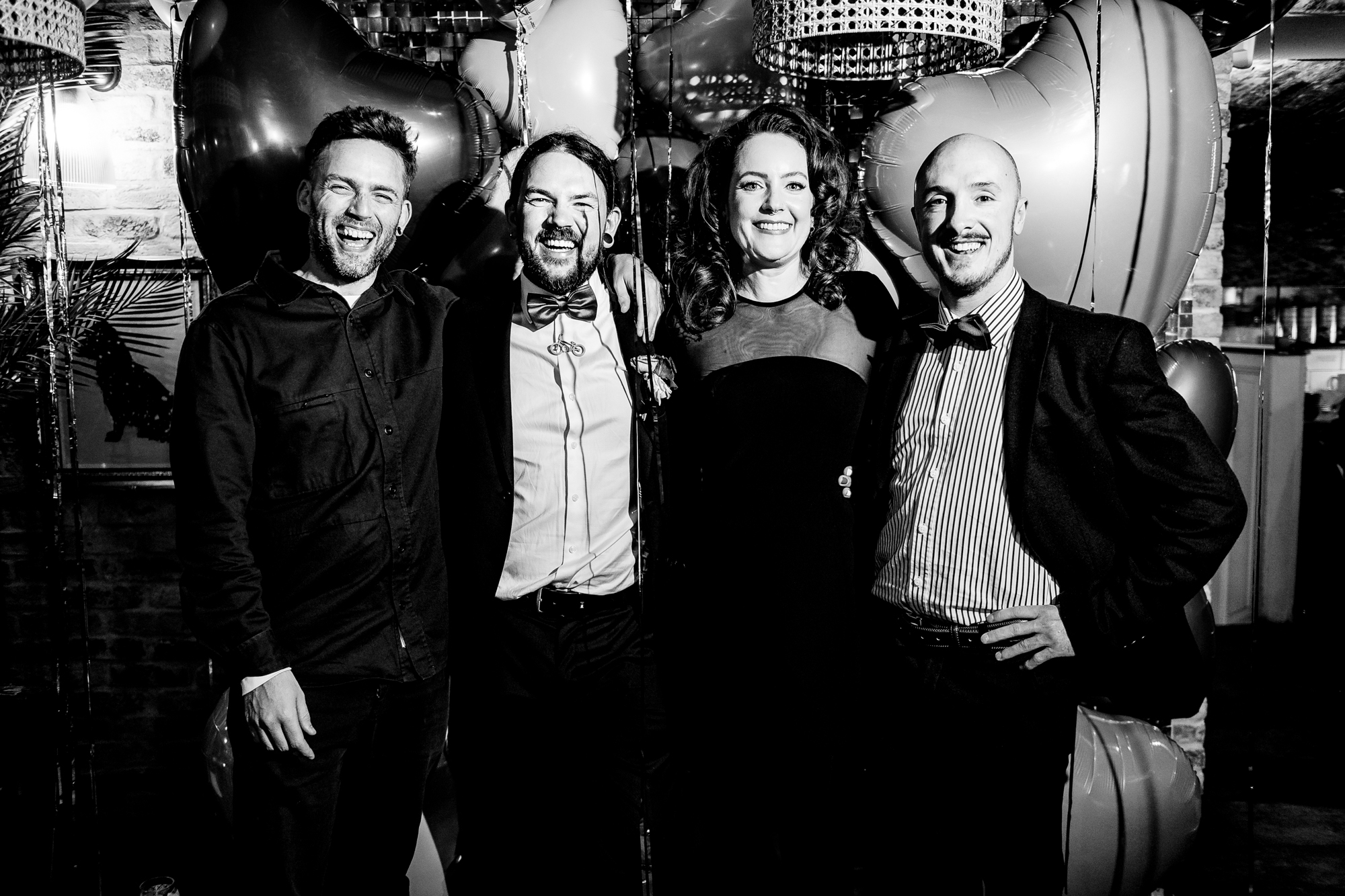 Guests with the bride and groom smiling together during the evening celebration.