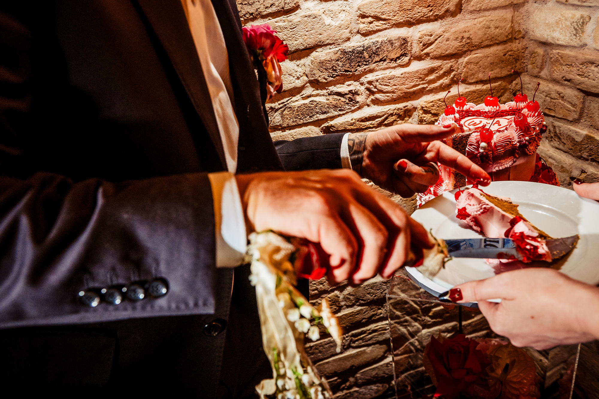 Close-up of cake being served onto plates beside the ribbon-wrapped vintage wedding knife.