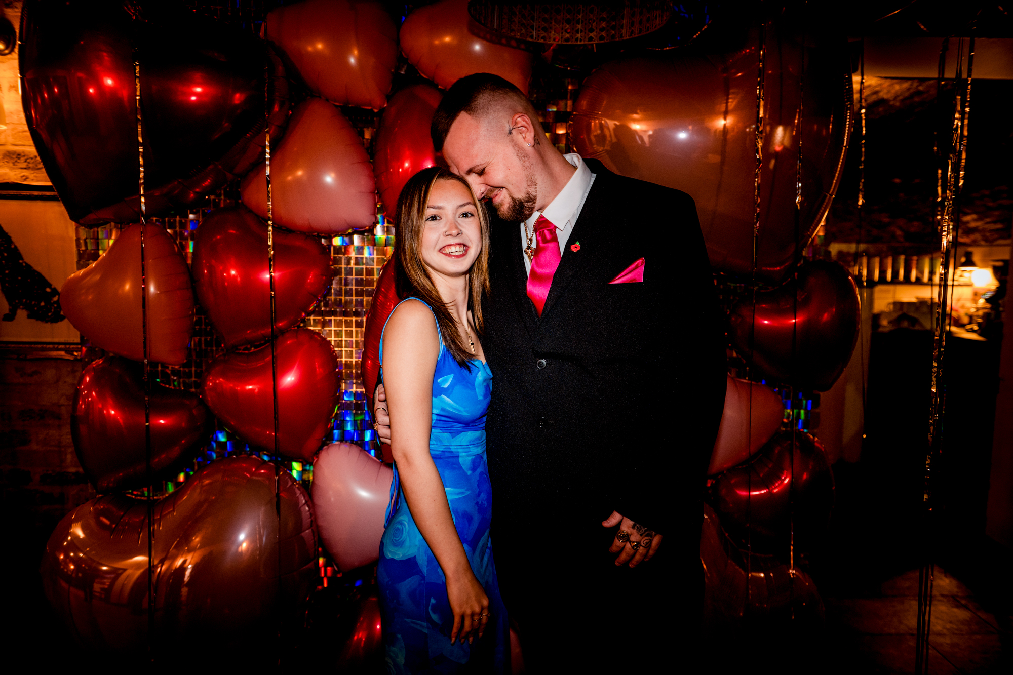 Couple smiling in front of heart balloons during their wedding party at Racks Bristol.
