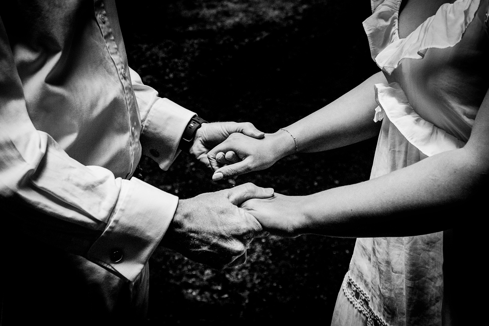 Black and white detail of the couple holding hands during their West Woods engagement session.