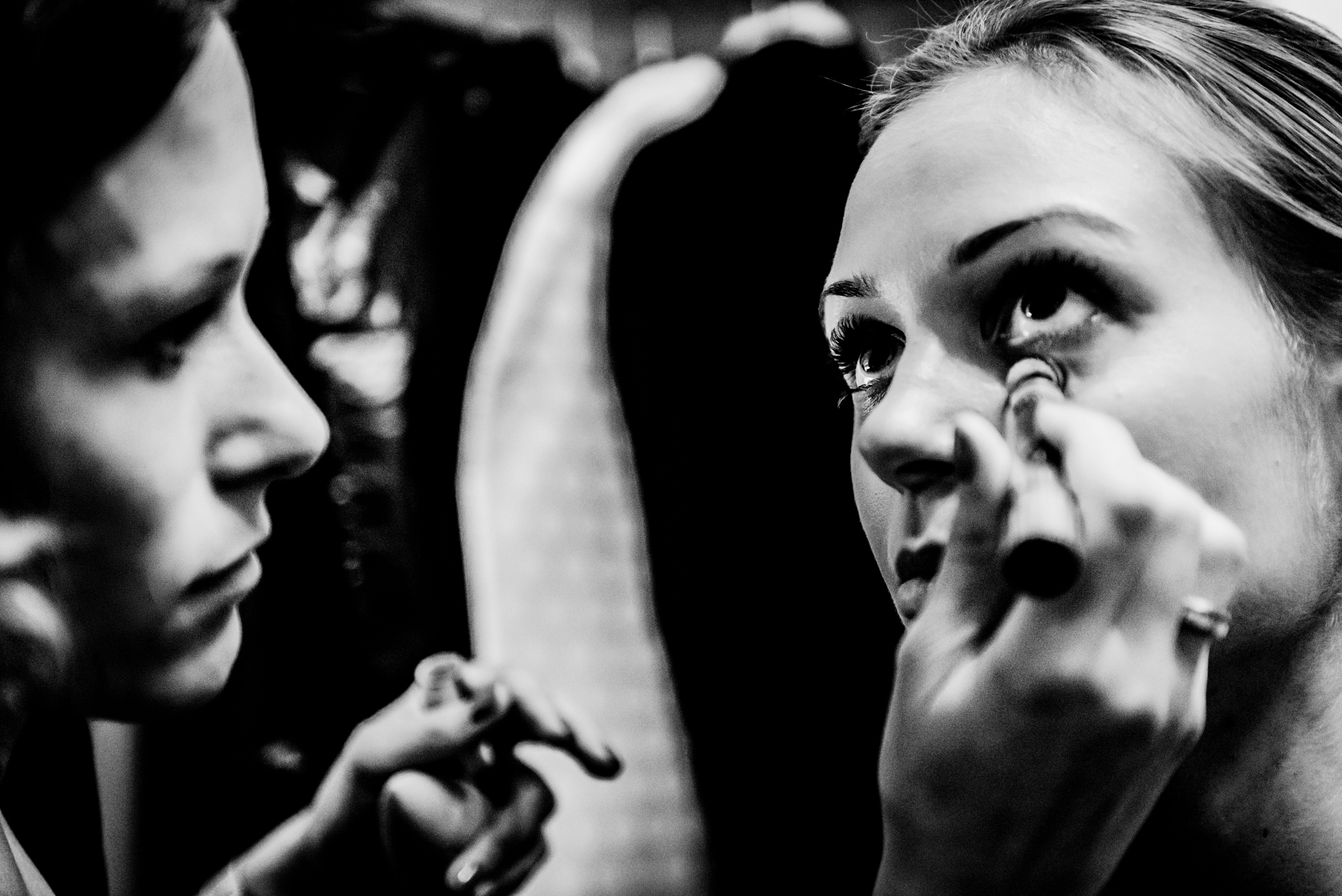 Close-up of a bridesmaid having eye makeup applied before the wedding ceremony.
