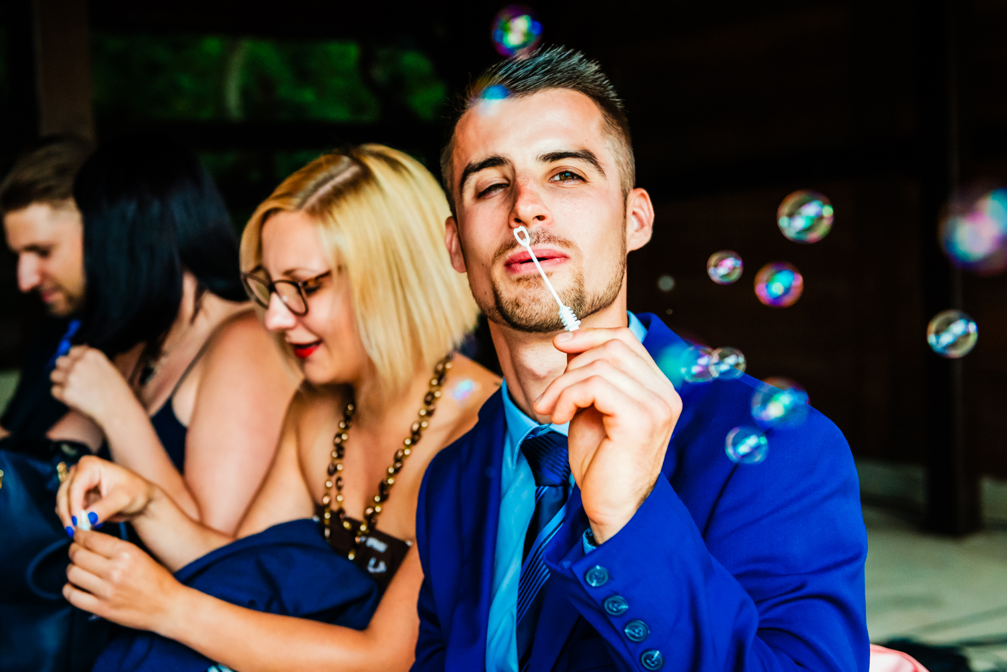 Wedding guest blowing bubbles during outdoor celebration at Csillagkert wedding venue.