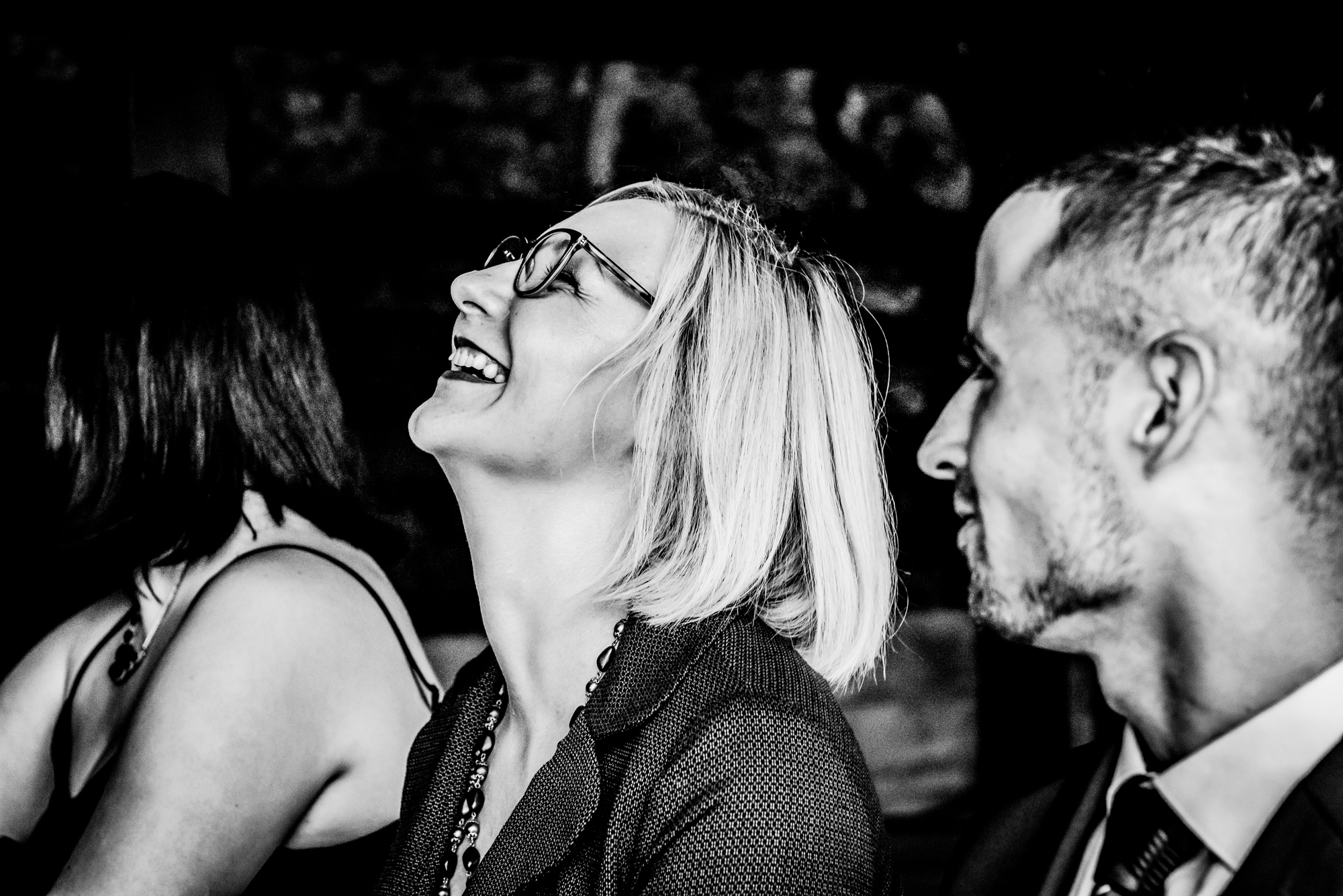 Candid wedding guest reaction during emotional wedding speech or ceremony moment.