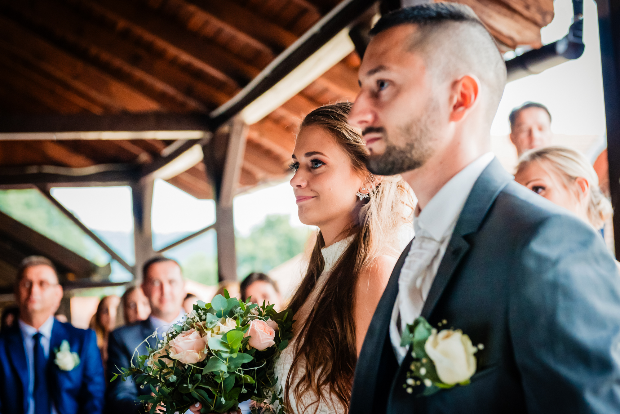 Bride and groom listening during their intimate ceremony surrounded by wedding guests.