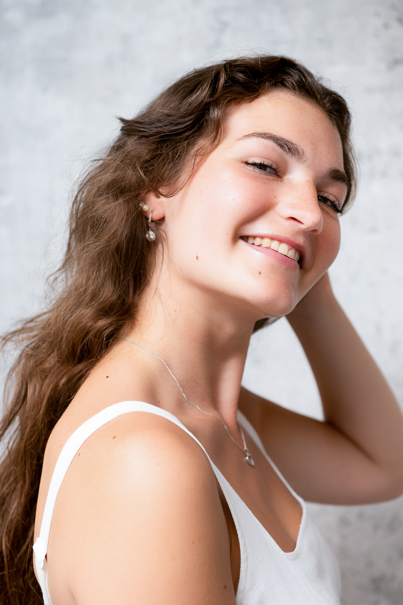 Close-up editorial portrait of woman with long brown hair at a portrait studio in Bristol.