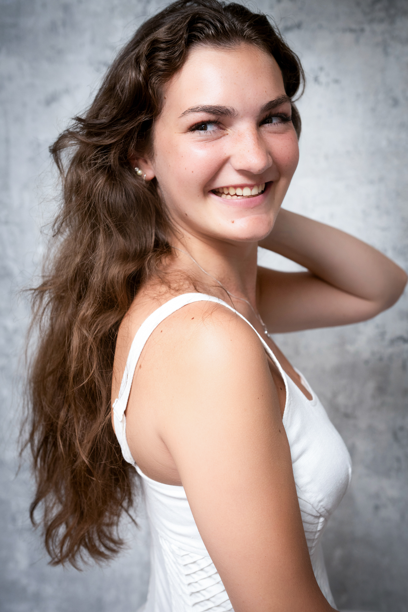 Close-up portrait of smiling woman with soft natural makeup during studio branding session.