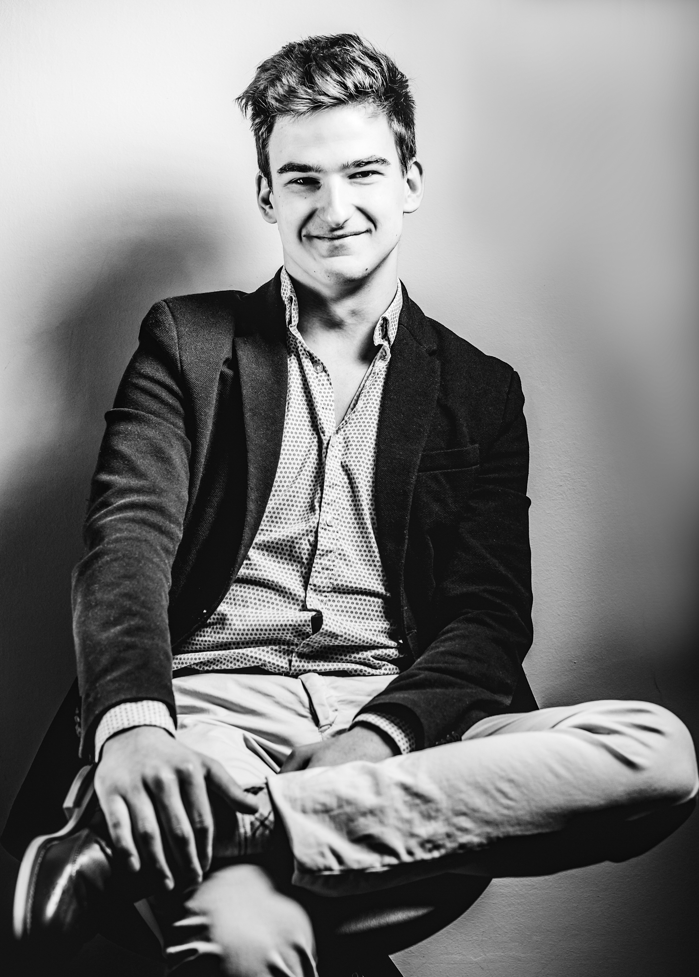 Young professional sits casually in a chair during a Personal Branding Photoshoot Budapest Airbnb session.