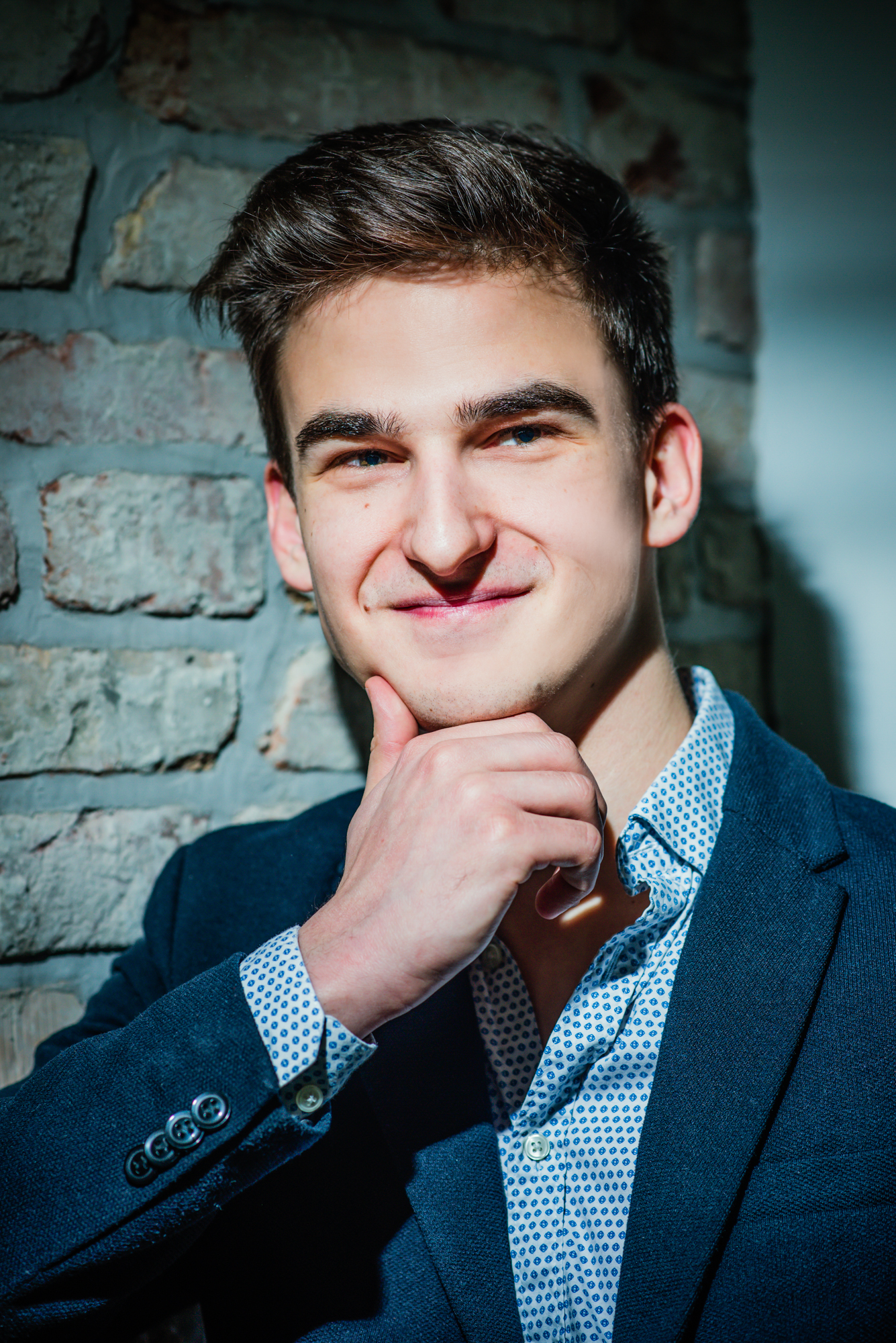 Ádám smiles beside an exposed brick wall during a Personal Branding Photoshoot Budapest.