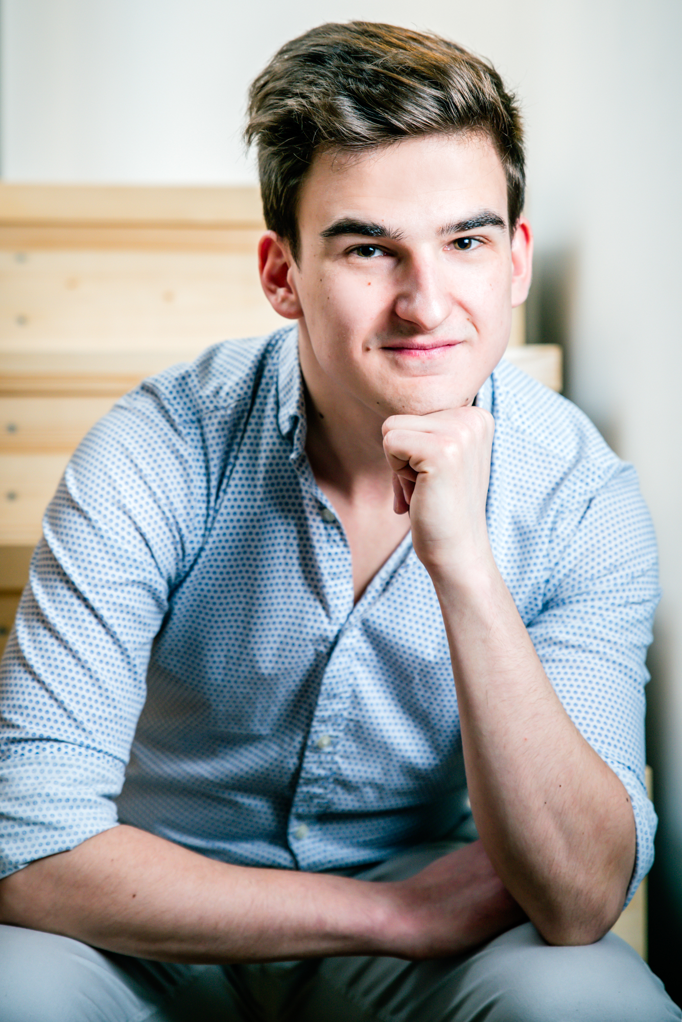 Natural personal branding portrait of Ádám seated indoors during a Budapest portrait session.
