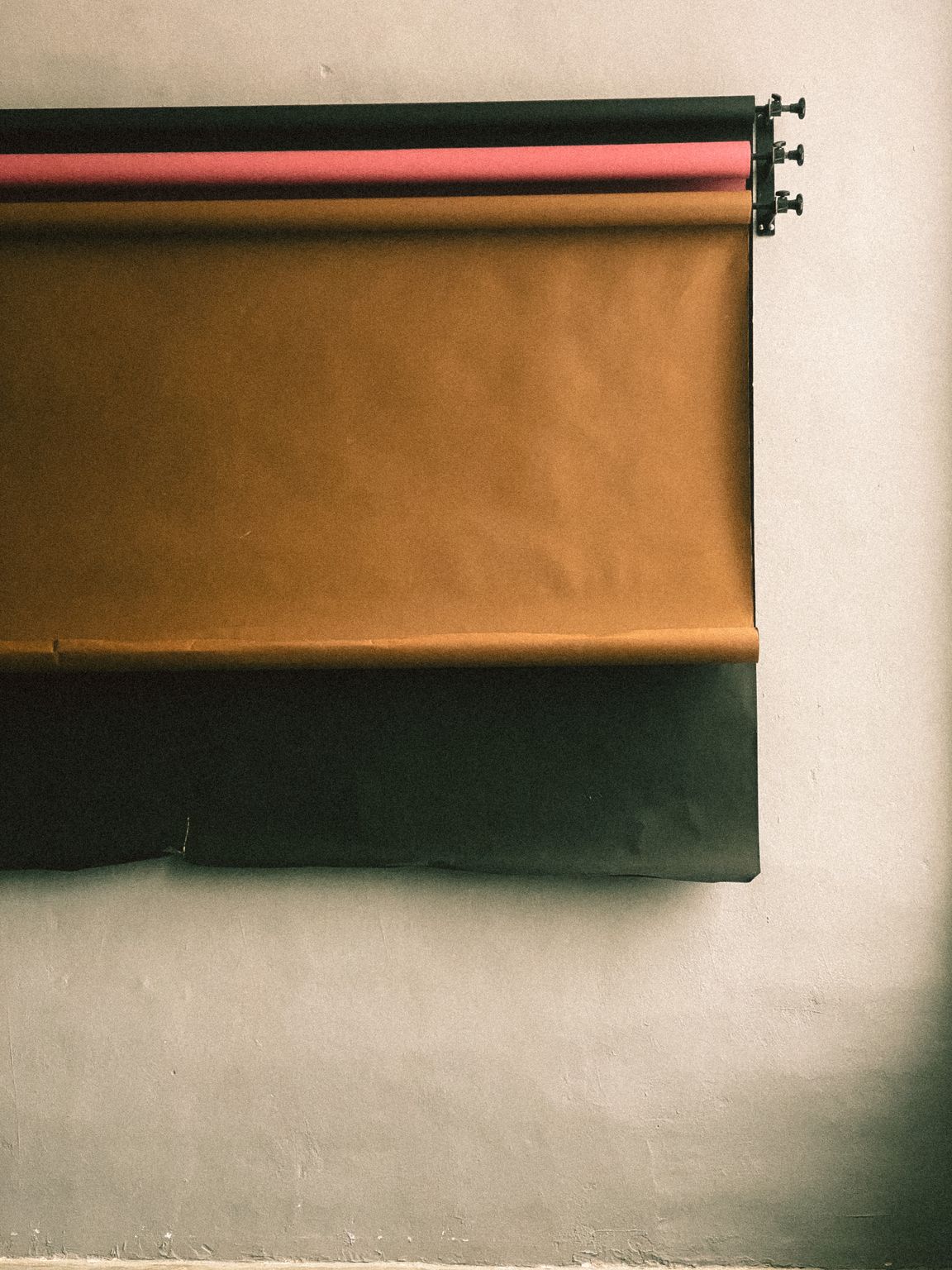 A variety of colored paper rolls in a photography studio setting.